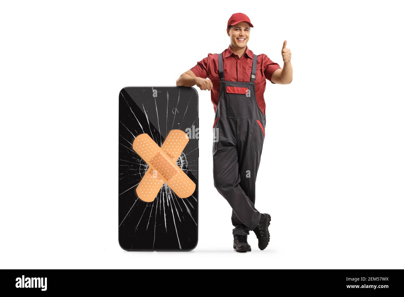 Technician leaning on a smartphone with a cracked screen and band aid and gesturing a thumb up sign isolated on white background Stock Photo