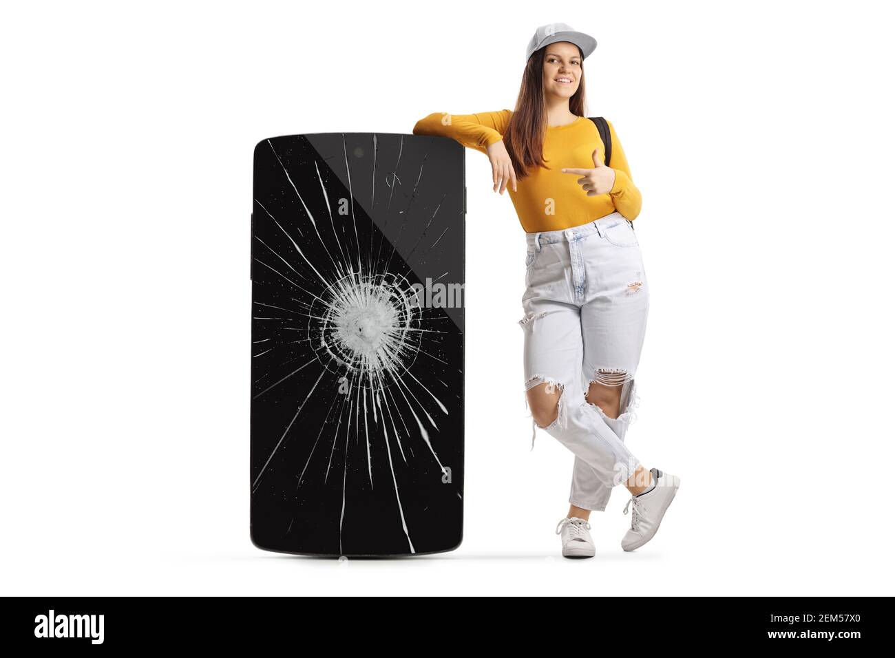 Full length portrait of a young female with a big broken phone pointing isolated on white background Stock Photo