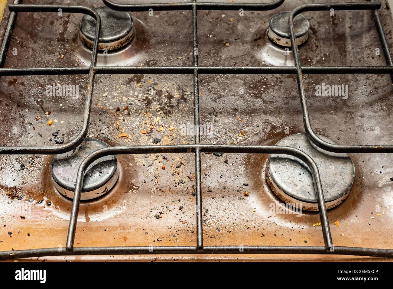 The gas stove is covered in grease and stains of dirt.Unsanitary conditions and mess in the kitchen. Stock Photo