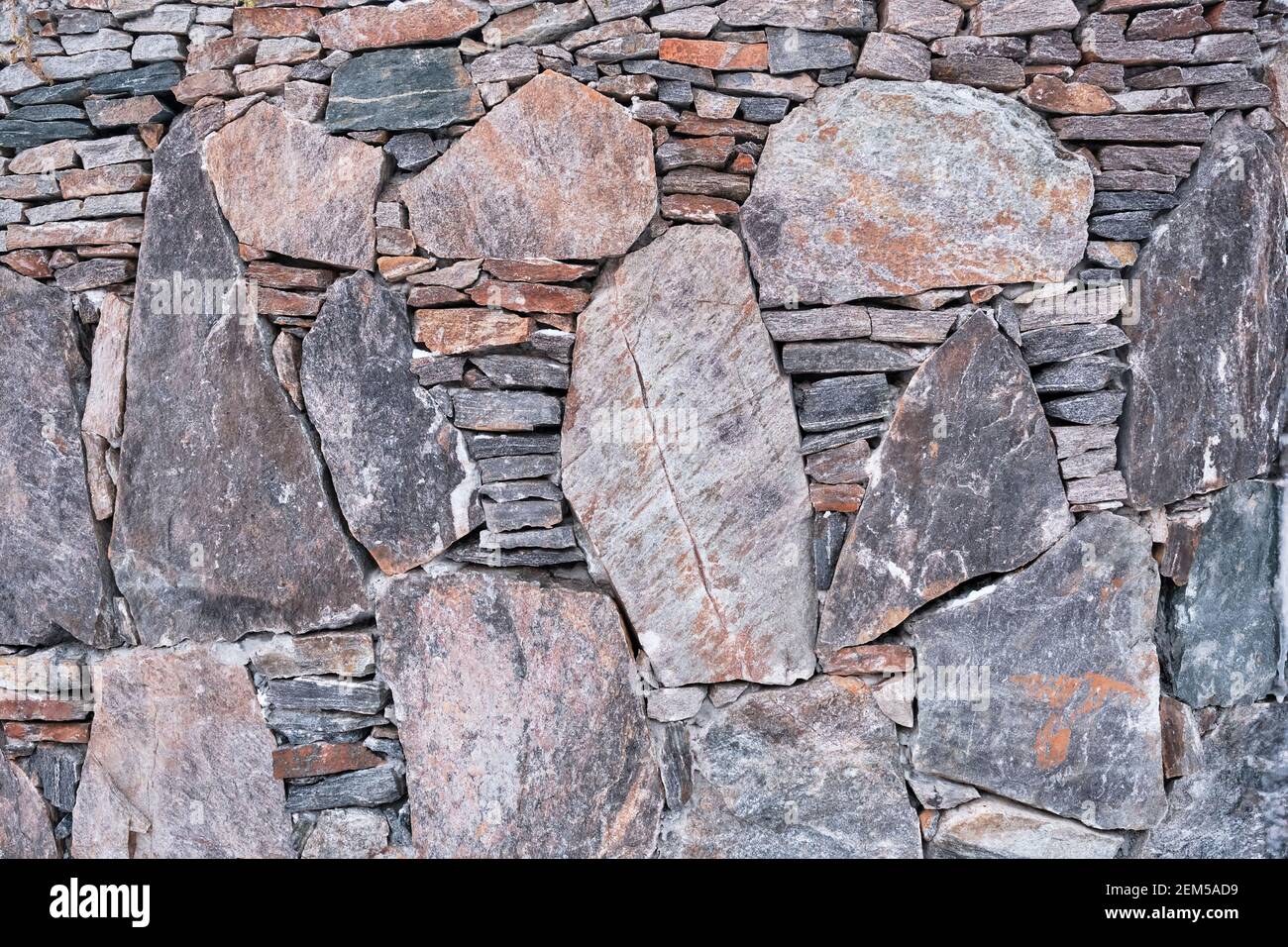 Texture of a gray and brown wall made of stones laid horizontally and ...