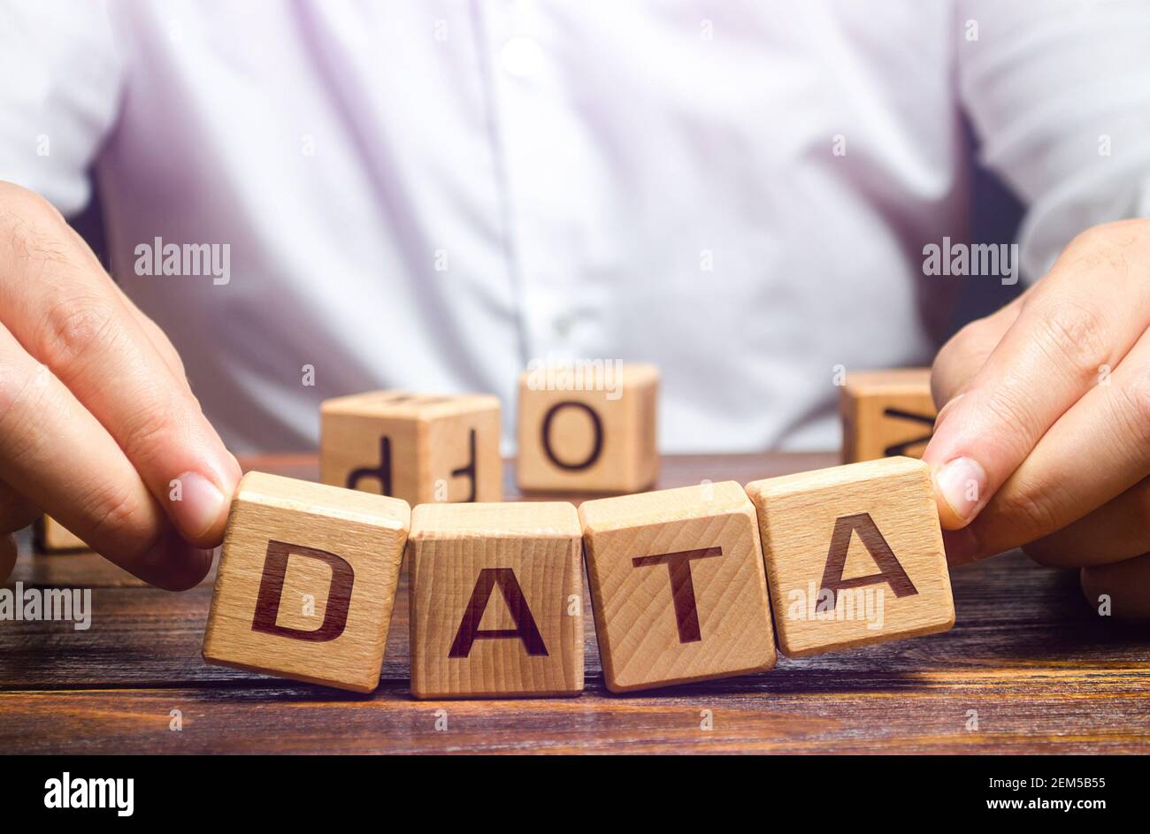 The man tries to pick up blocks with the word Data. Digital data integrity and security vulnerability concept. Fault tolerance, backup. Financial data Stock Photo