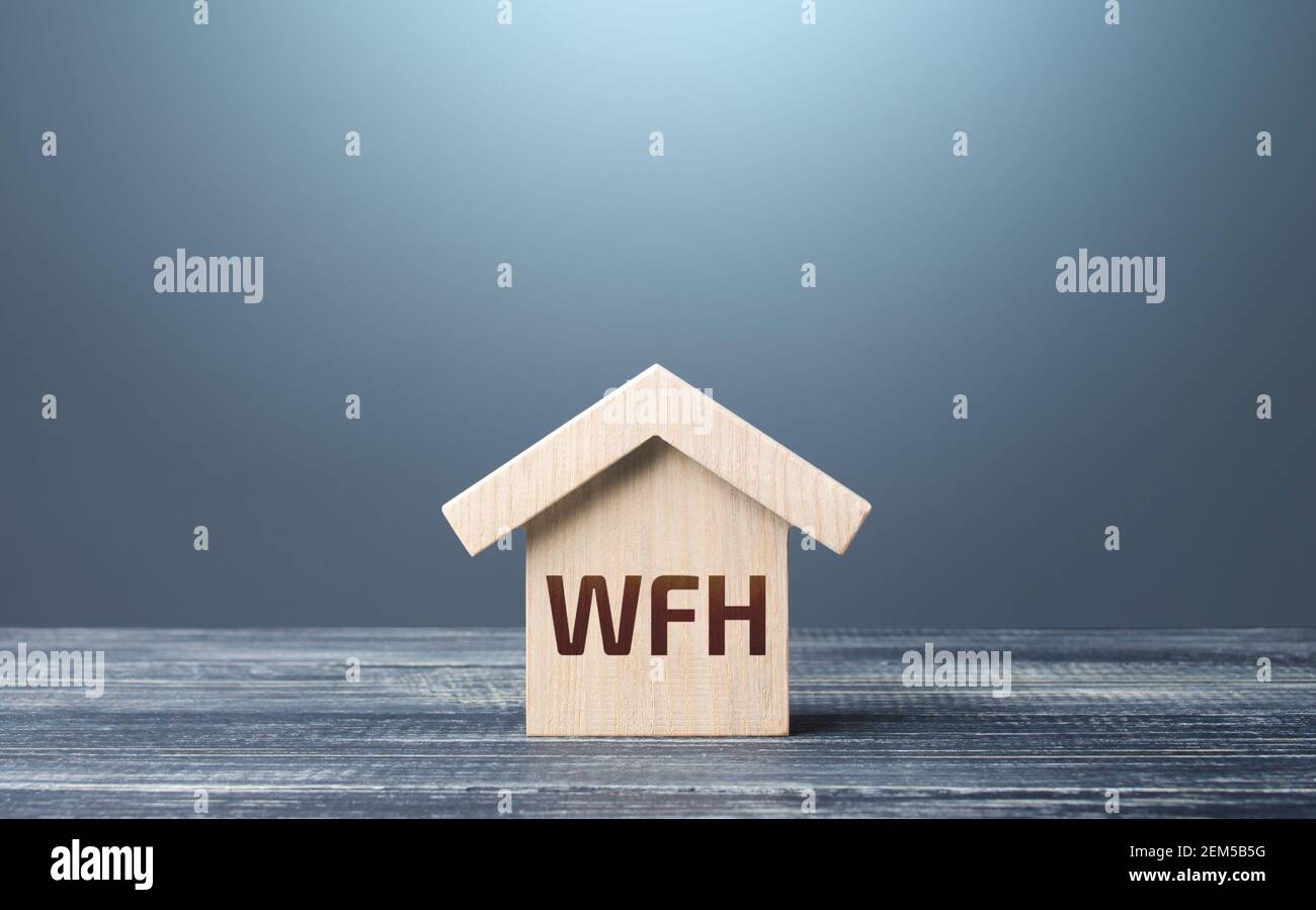 Wooden house figurine with abbreviation WFH (work from home). New normal. Strict requirements and restrictions policies in the work of company. Revisi Stock Photo