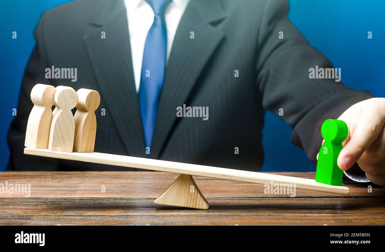 Man opposes green man to group of people on scales. Appointment of a leader. A talented employee is more productive. Set as an example. Give a head st Stock Photo