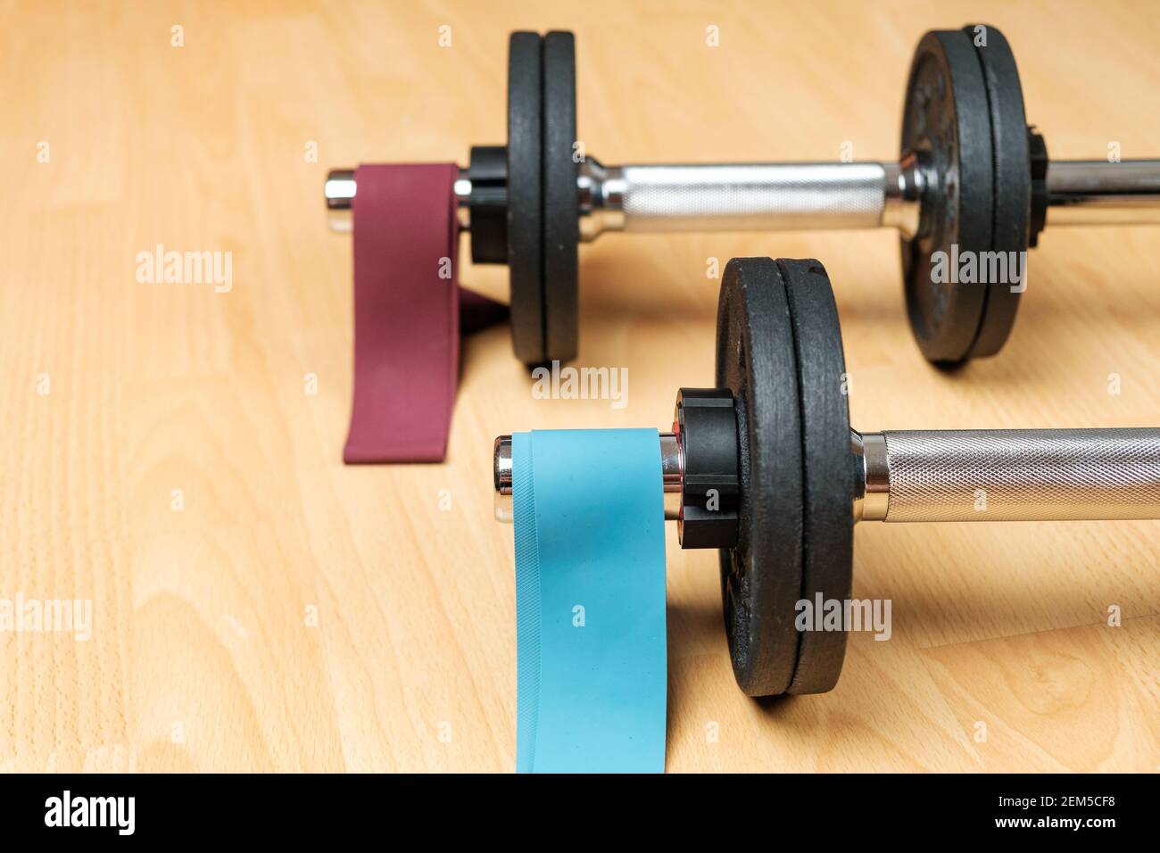 Dumbbells and elastic bands on the floor at home. Keeping fit during lockdown. Fitness equipment for strength training  Stock Photo