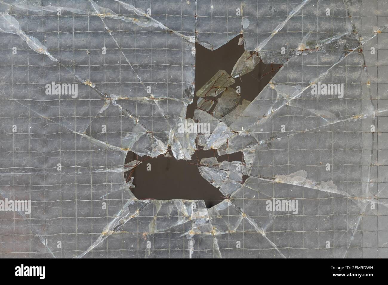 Broken wire mesh safety glass window. Background texture. Stock Photo