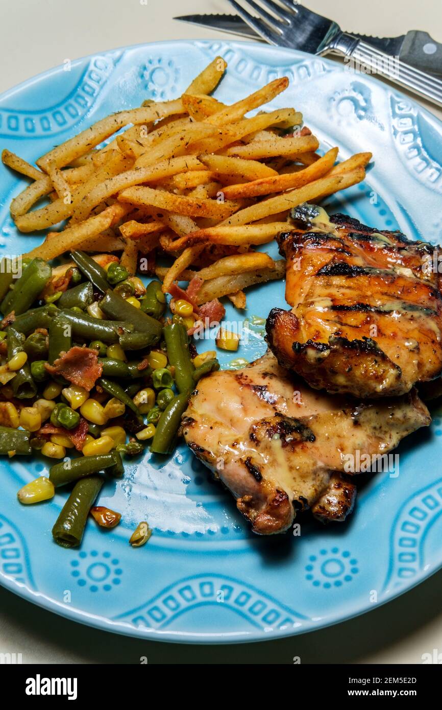 Honey mustard grilled chicken thigh dinner served with homemade shoestring French fries and