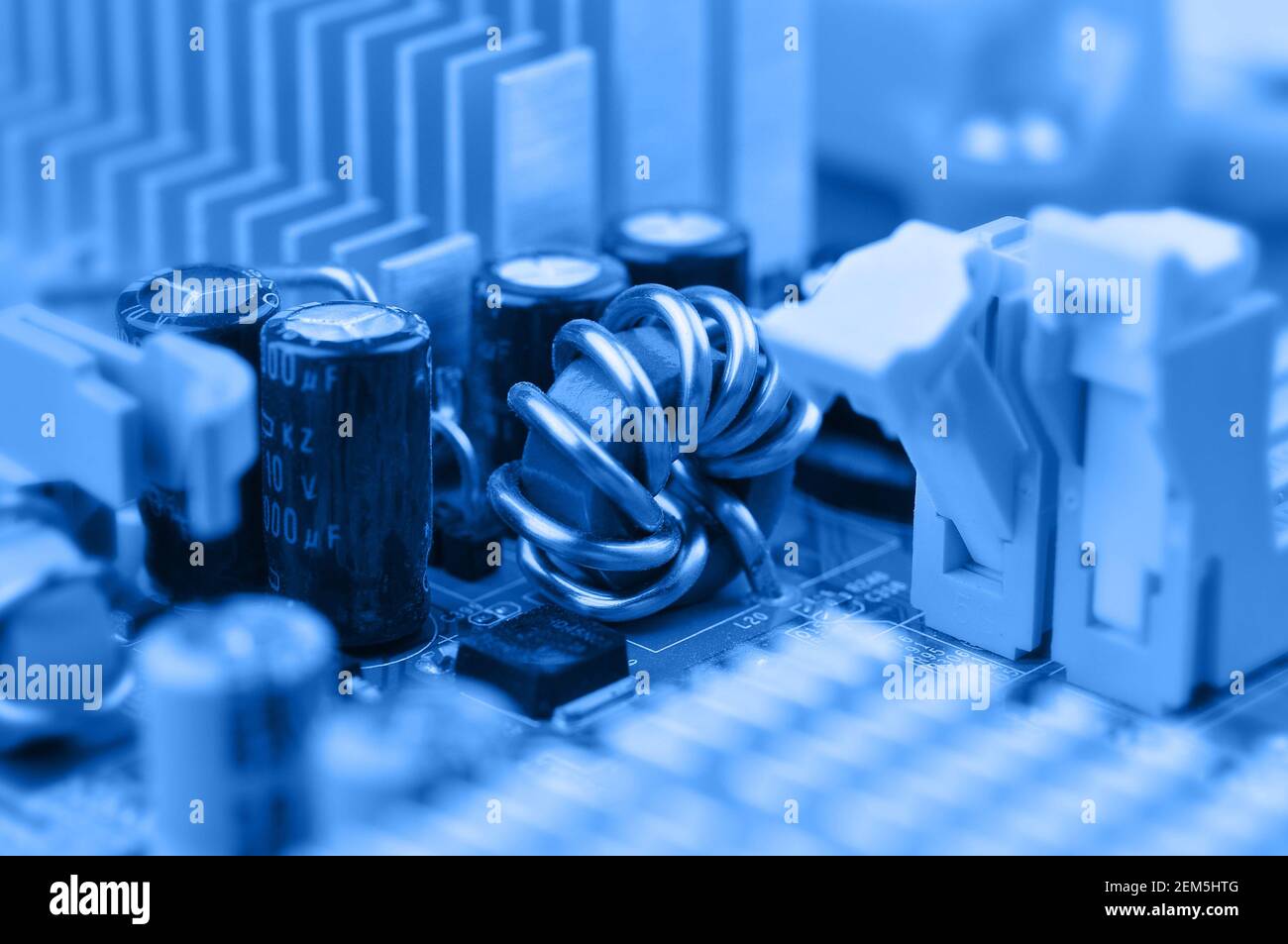 Closeup of electronic circuit board with inductor coil and capacitor. Stock Photo