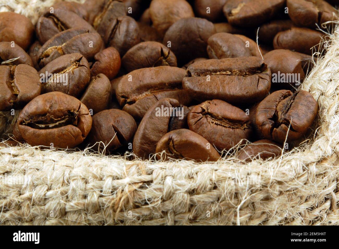 Roasted coffee beans in sacking bag. Selective focus. Stock Photo