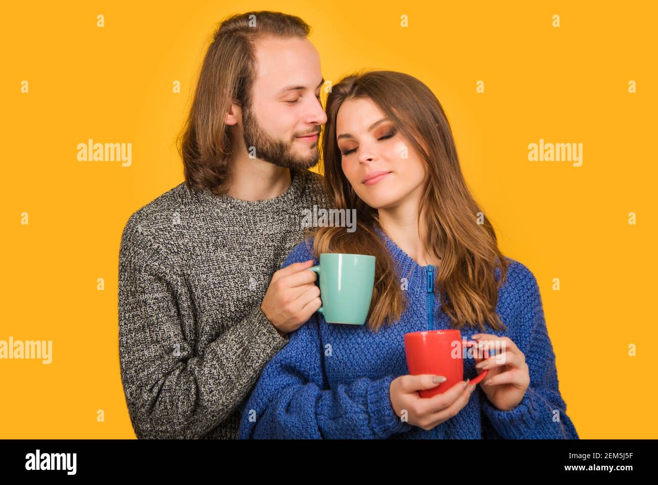 Happy morning together. Lovely couple with cup of tea. Family in warm clothes with mug of hot drink. Stock Photo