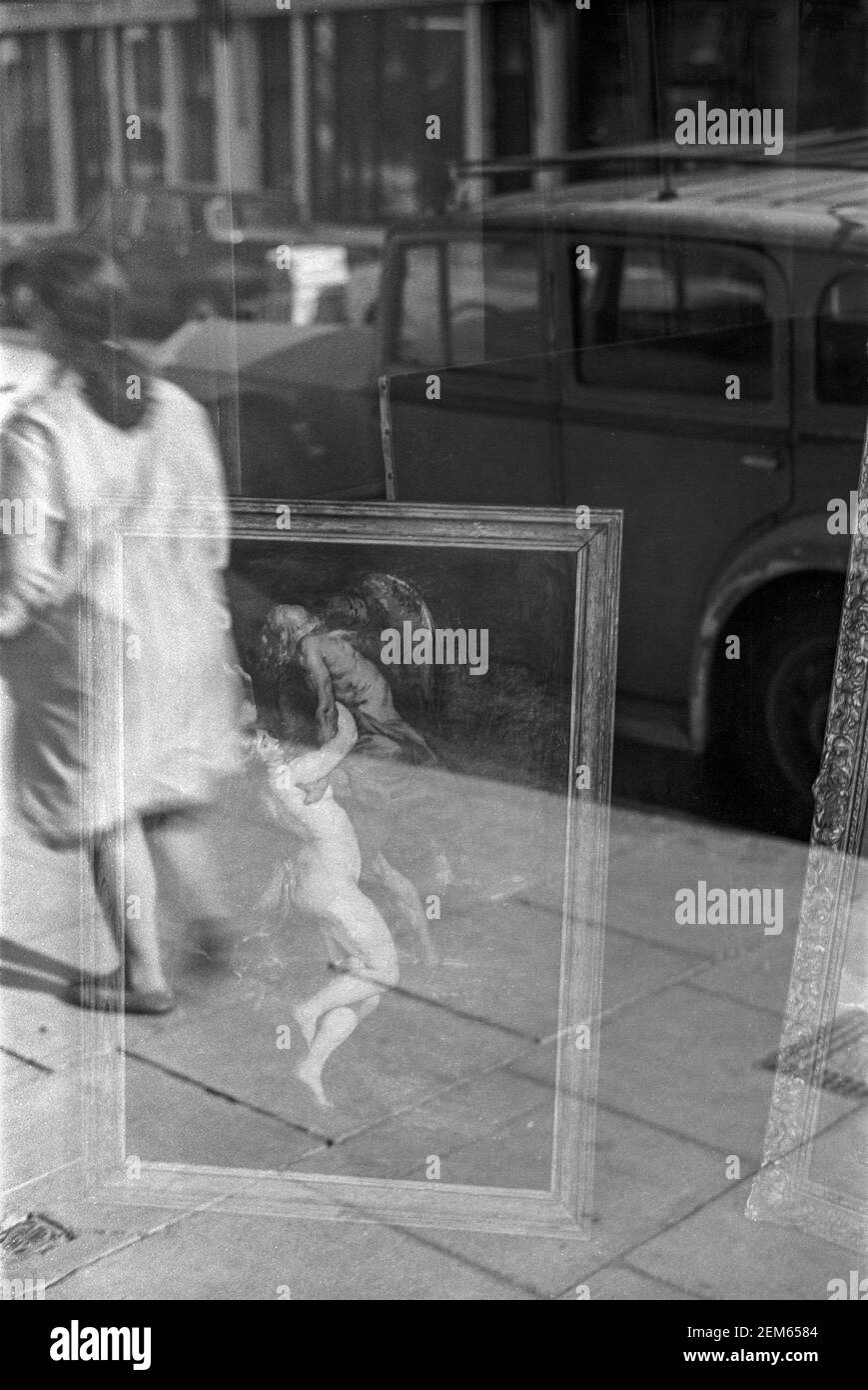UK, West London, Notting Hill, 1973. Reflections in a shop window selling antiques & paintings. Stock Photo