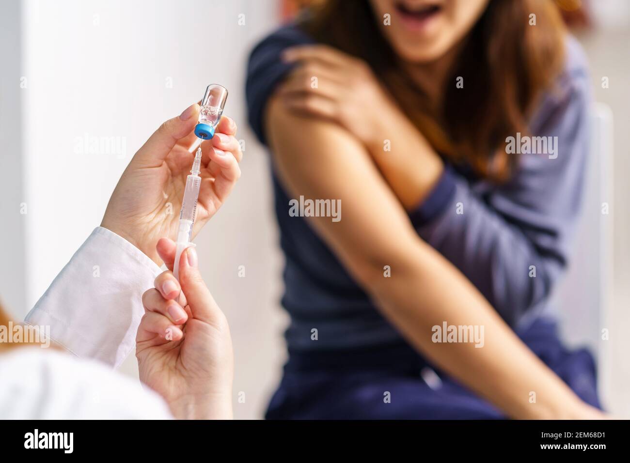Vaccination healthcare concept - Hands of doctor or nurse hold a syringe and ampule preparing a shot of corona virus covid-19 hpv or flu vaccine for u Stock Photo