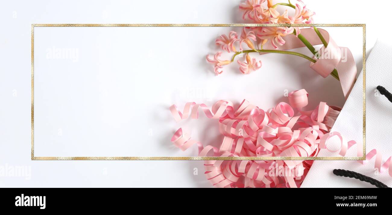 Pink spring flowers, pink gift streamer in white gift bag on white background. Beautiful spring card for Birthday, Woman, Valentines, Mothers Day in p Stock Photo
