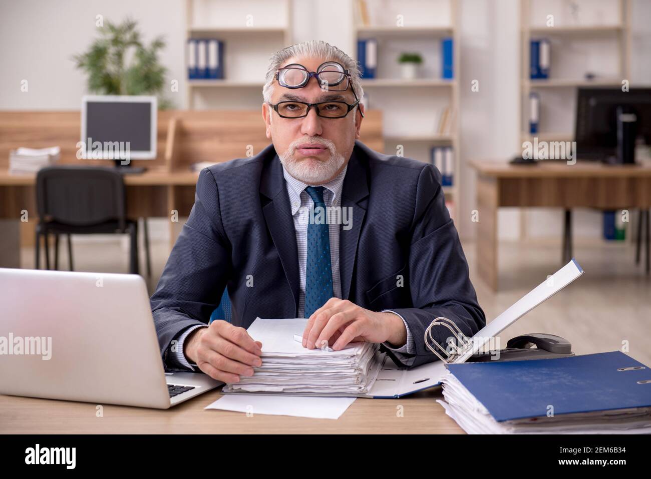 Old employee auditor wearing many glasses at workplace Stock Photo Alamy