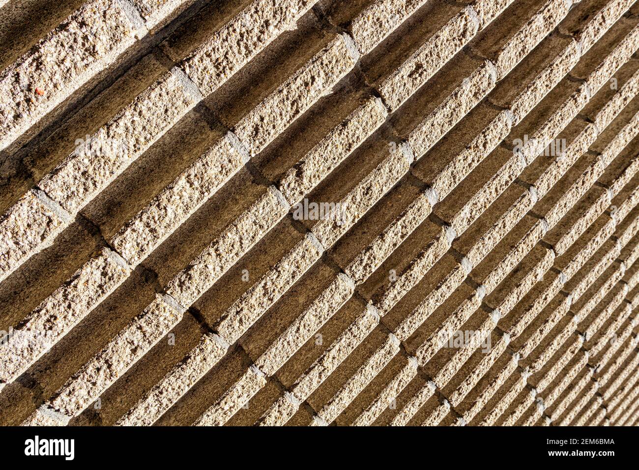 A grooved concrete exterior wall shot at an angle makes diagonal lines