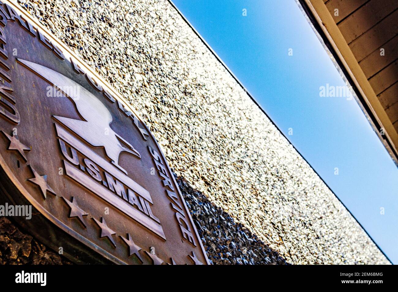 The roof, sky, and USPS logo, on the pebbledash exterior of the Grace