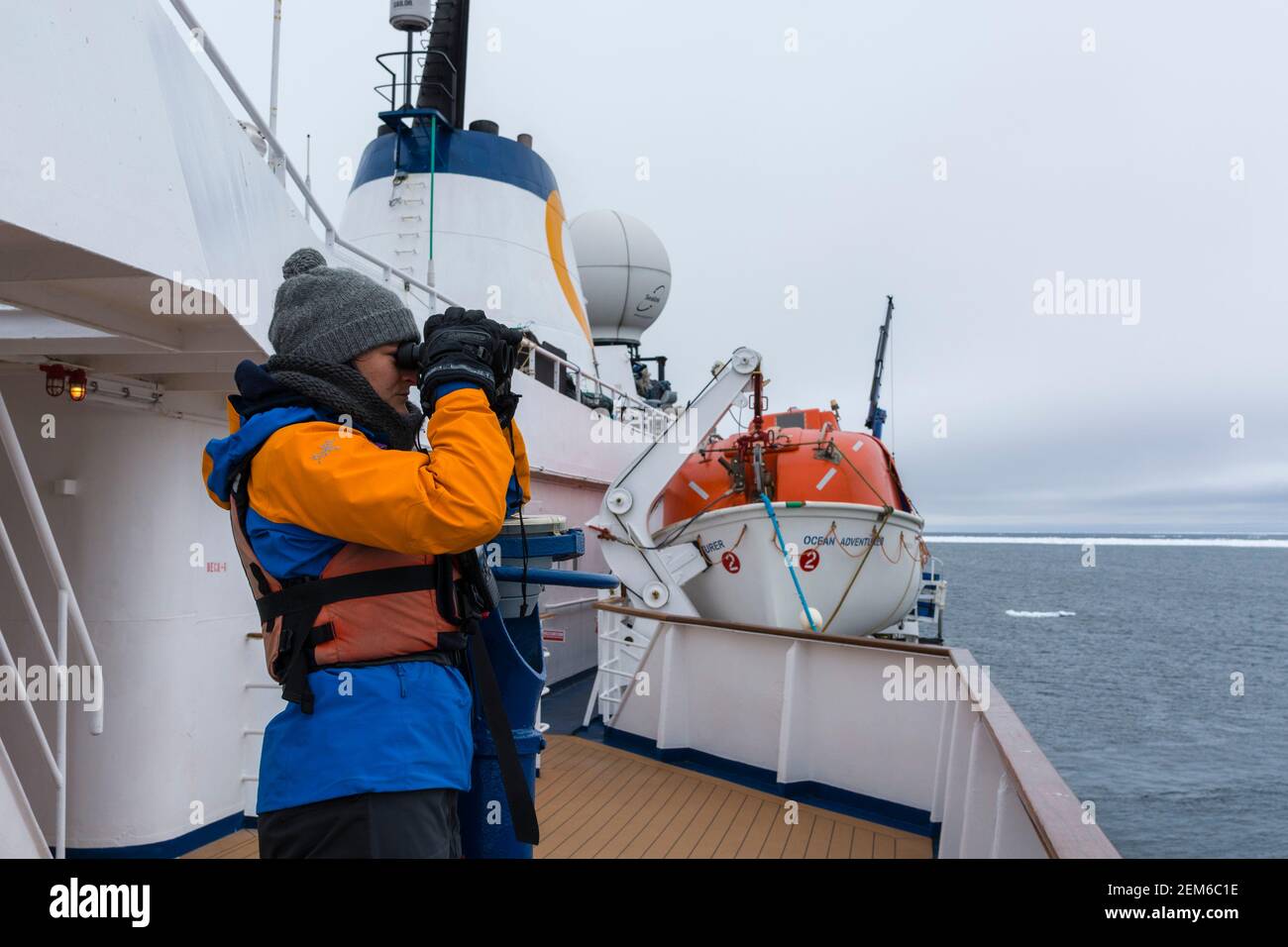 A guide of the cean Adventure cruise ship surveying the Polar Ice Cap in search of polar  bears, 81north of Spitsbergen, Norway. Stock Photo