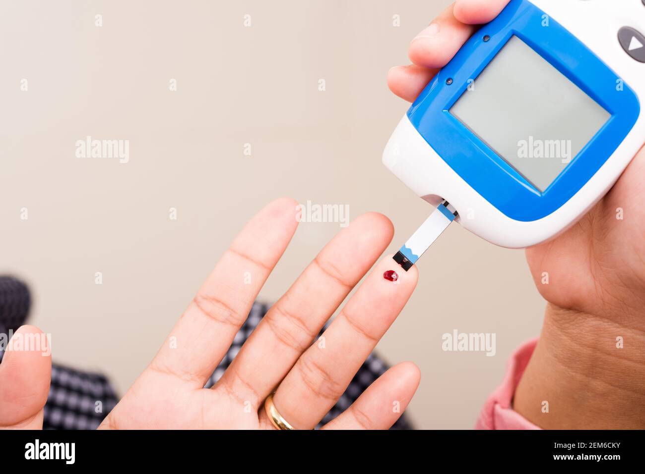 Closeup Hands woman measuring glucose test level check with blood on