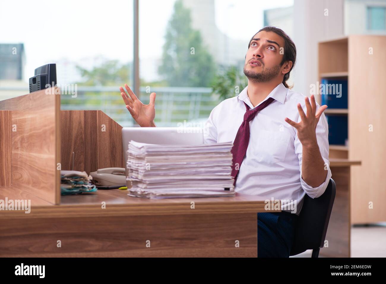 Young employee and too many work in the office Stock Photo - Alamy