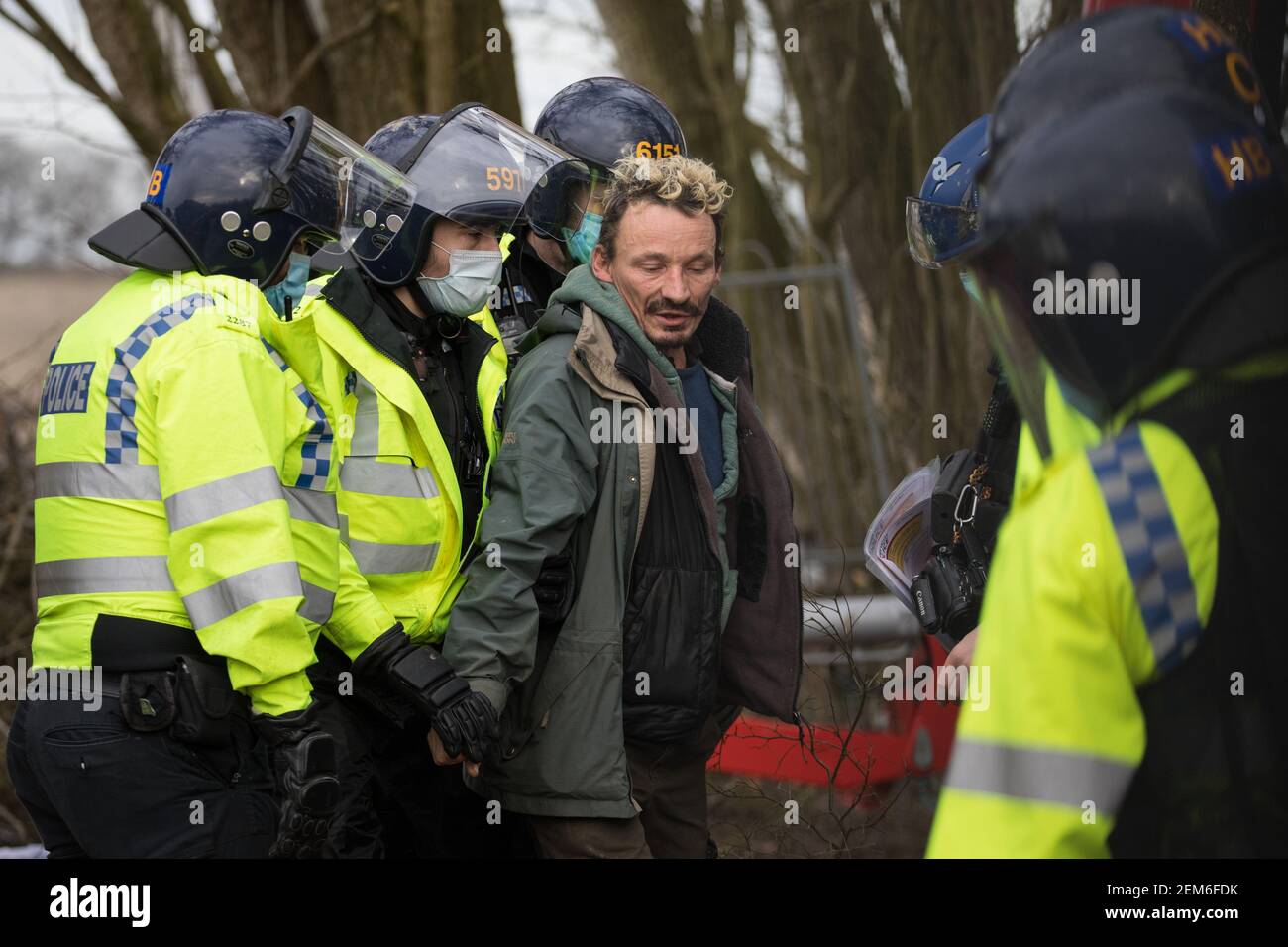 Steeple Claydon, UK. 24 February, 2021. Thames Valley Police officers arrest an activist opposed to the HS2 high-speed rail link after evicting him from ancient woodland known as Poors Piece. Thames Valley Police stepped in to replace National Eviction Team bailiffs. The activists created the Poors Piece Conservation Project in the woodland in spring 2020 after having been invited to stay on the land by its owner, farmer Clive Higgins. Credit: Mark Kerrison/Alamy Live News Stock Photo