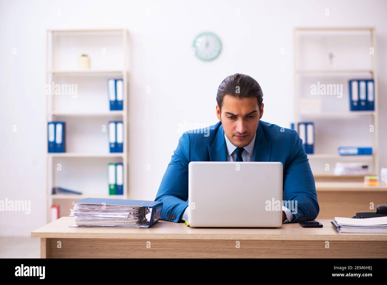Young employee and too many work in the office Stock Photo - Alamy