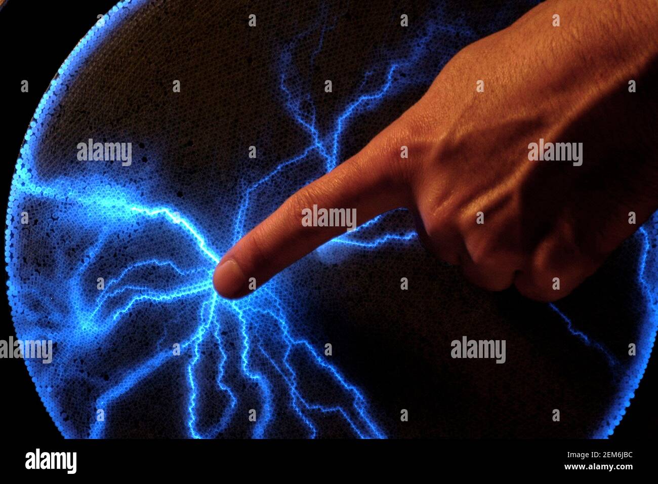 Human finger produce a blue electrostatic energy spark Stock Photo