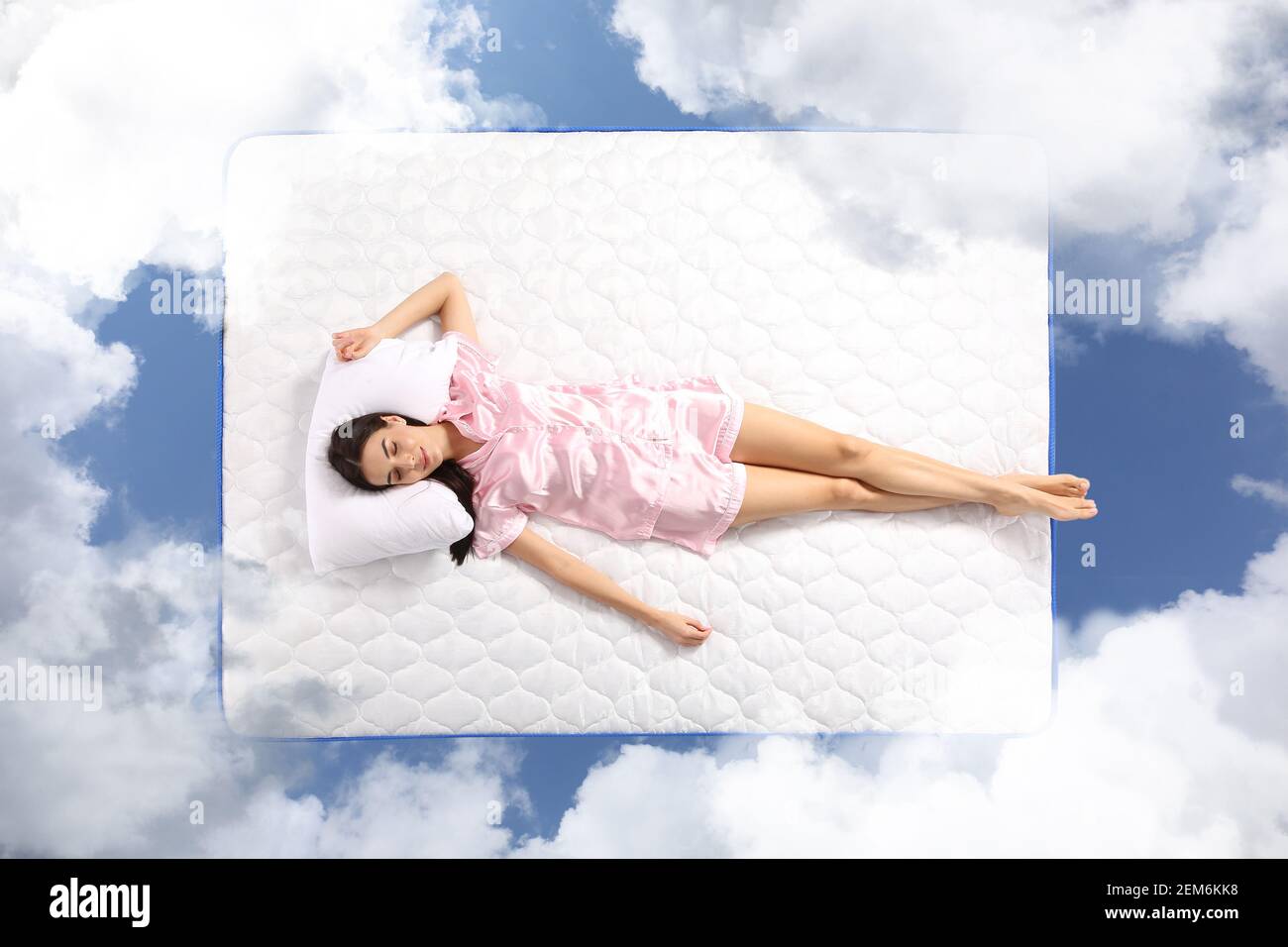 Young woman sleeping on mattress soft as clouds in blue sky Stock Photo ...