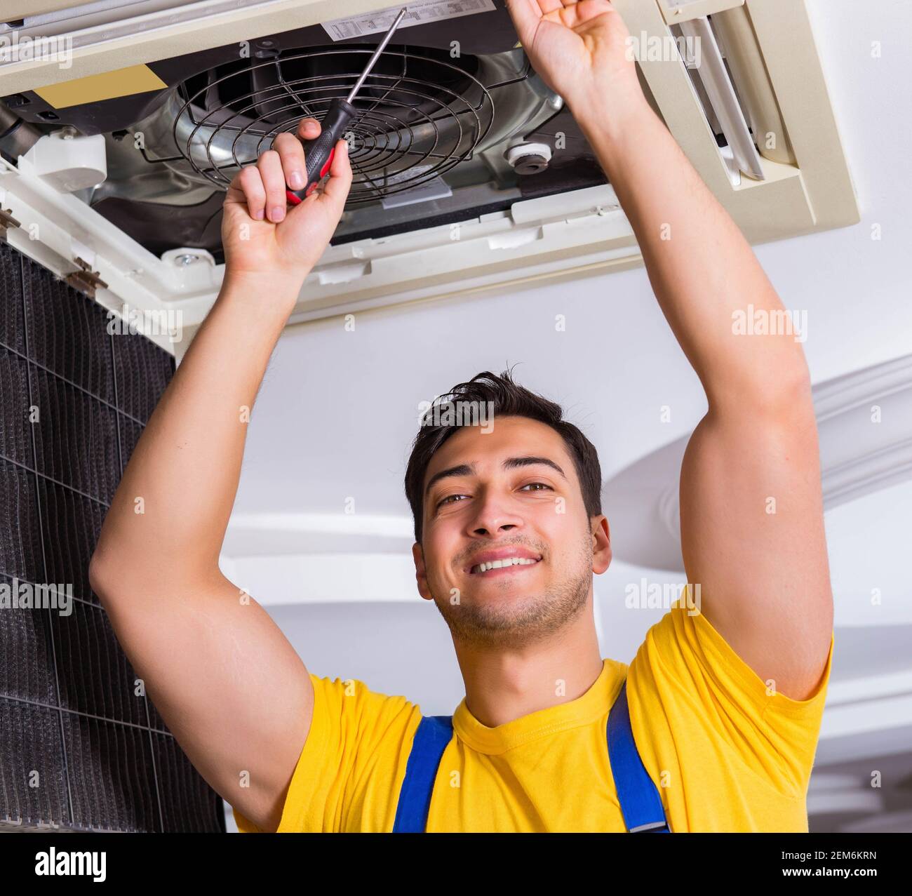 The repairman repairing ceiling air conditioning unit Stock Photo Alamy