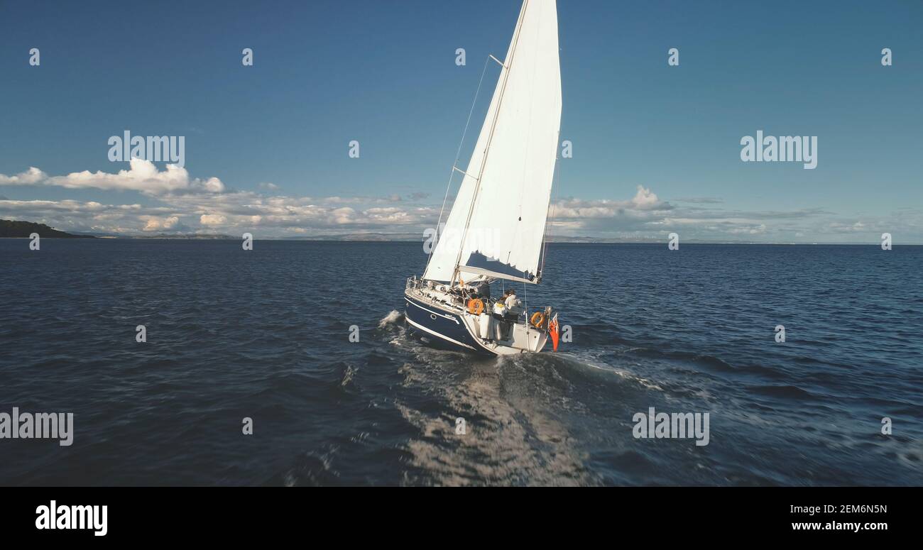 Closeup of yacht cruise at open sea with passengers aerial view. Sail boat at ocean with travelers tour. Majestic summer travel on sailboat at Brodick Gulf, Arran island, Scotland, Europe Stock Photo