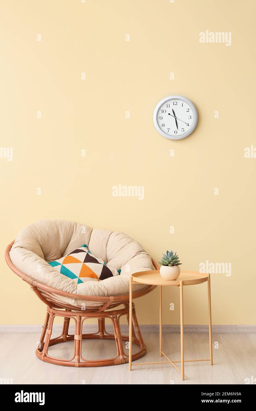 Stylish interior of living room with table and armchair Stock Photo - Alamy