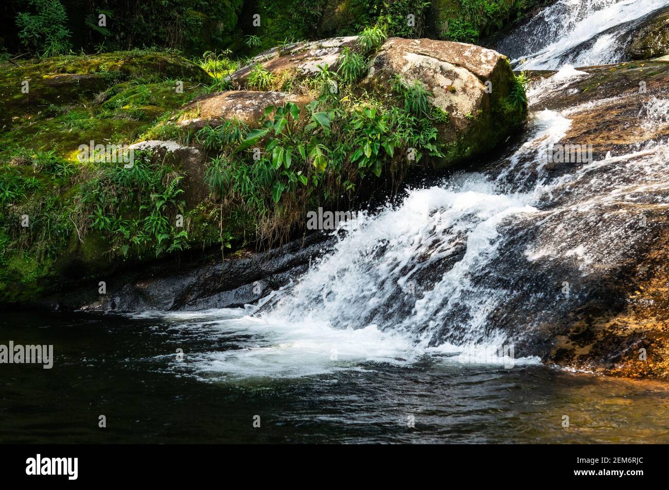 Water Current Flowing Around Rock Formations Covered In Moss Of 