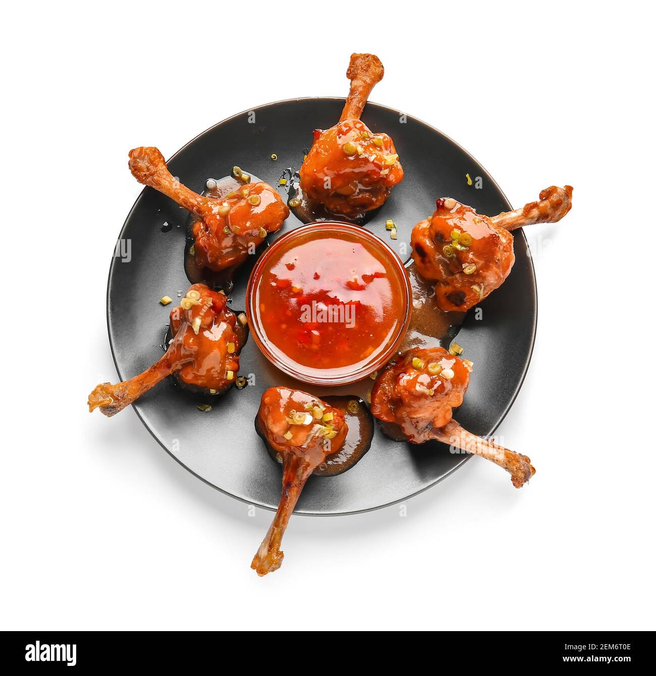 Plate with tasty chicken lollipops and sauce on white background Stock