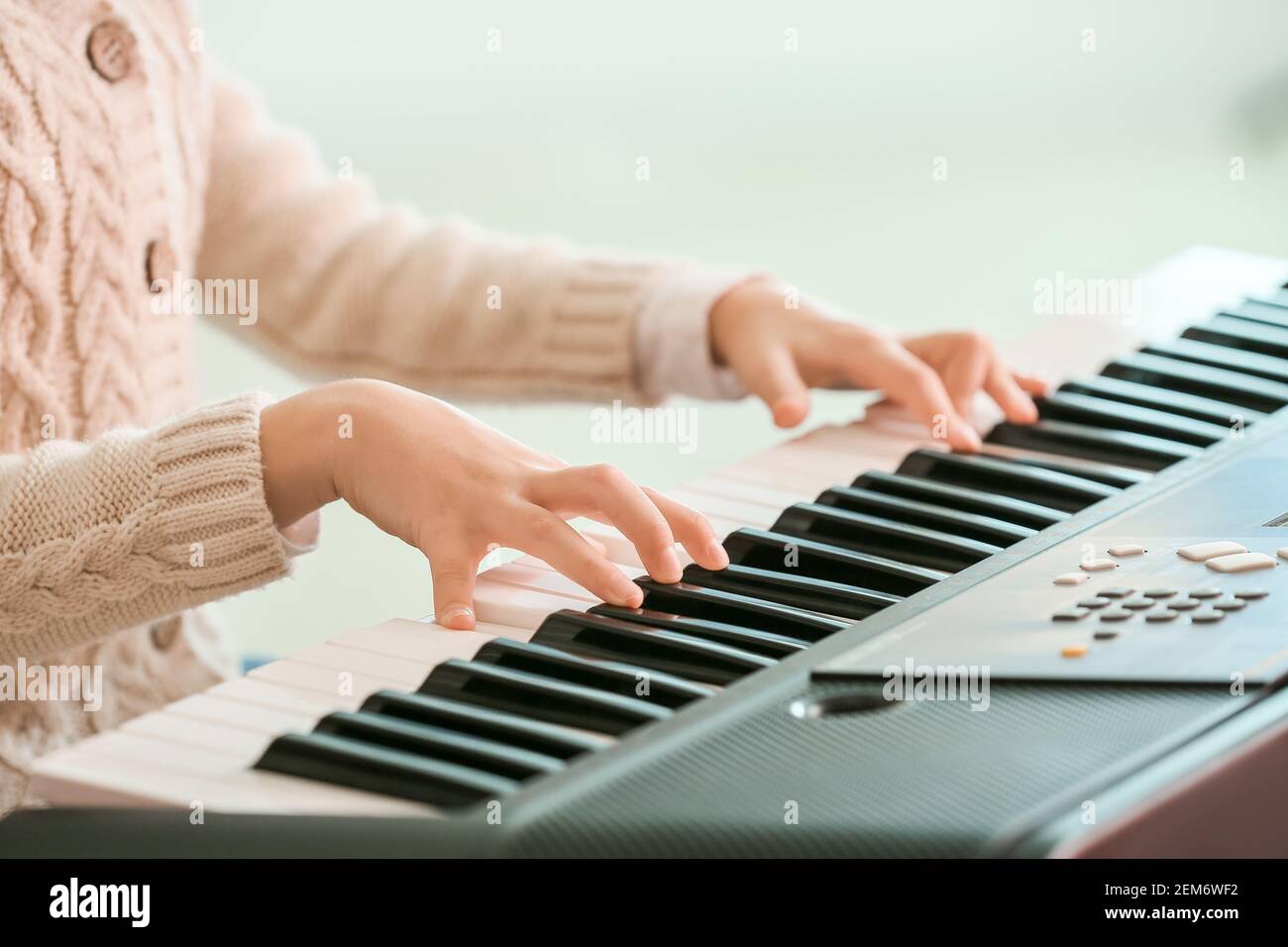 Little girl playing synthesizer at home, closeup Stock Photo