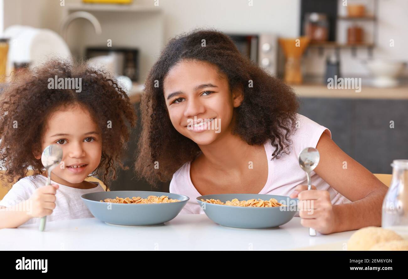 Cute African-American sisters having breakfast at home Stock Photo - Alamy