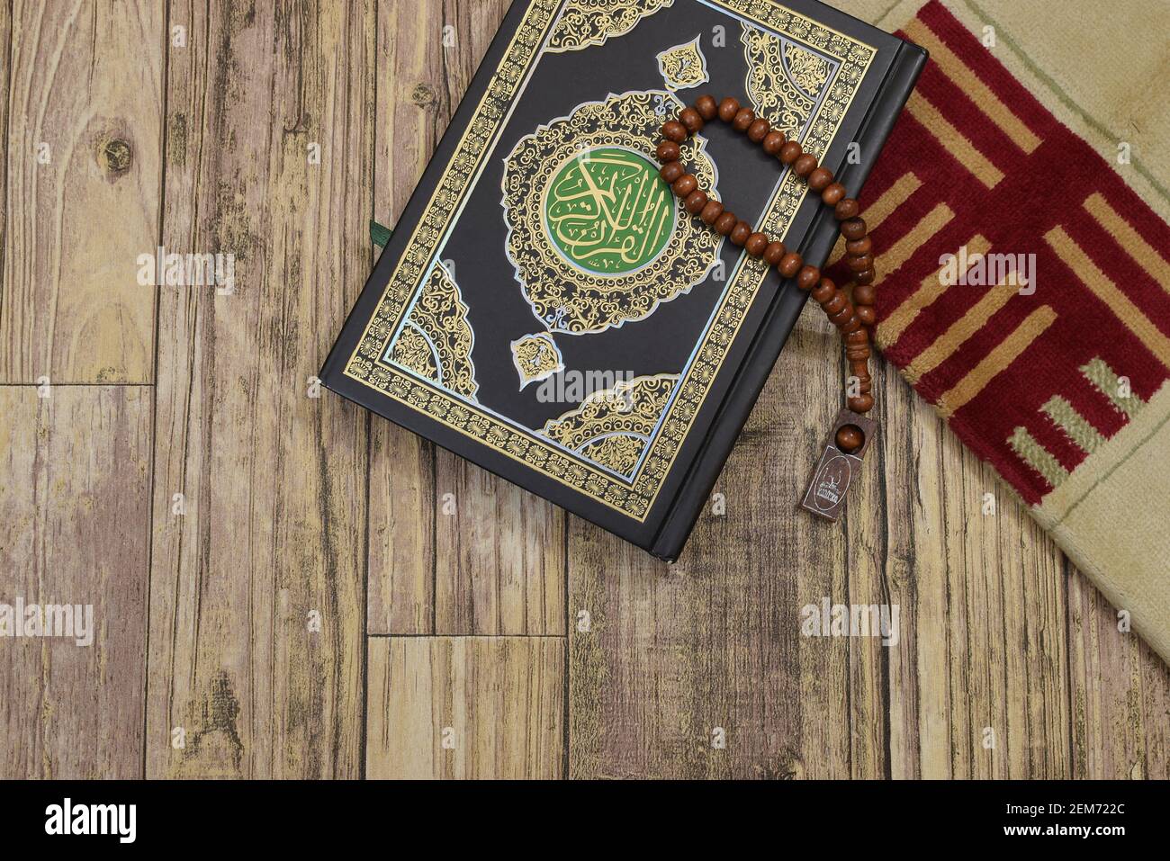 Holy Quran with tasbih and rug Stock Photo Alamy