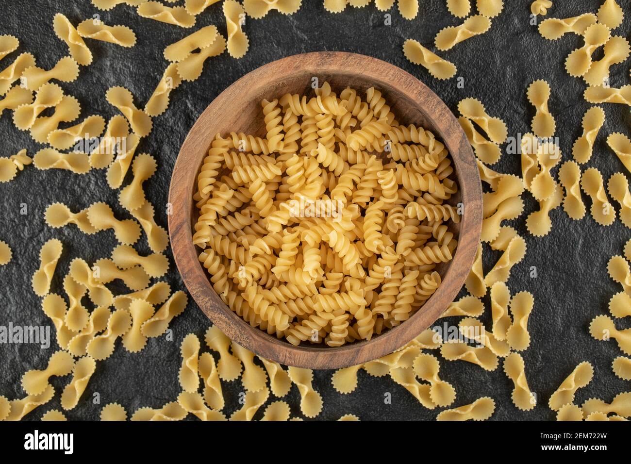 A wooden bowl full of raw girandole pasta Stock Photo