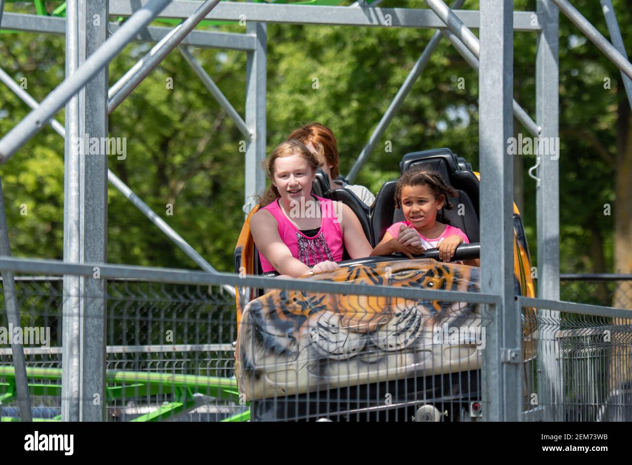 St. Paul, Minnesota.  13, 11 and 5 year old bi-racial sibling having fun on an amusement park ride. Stock Photo