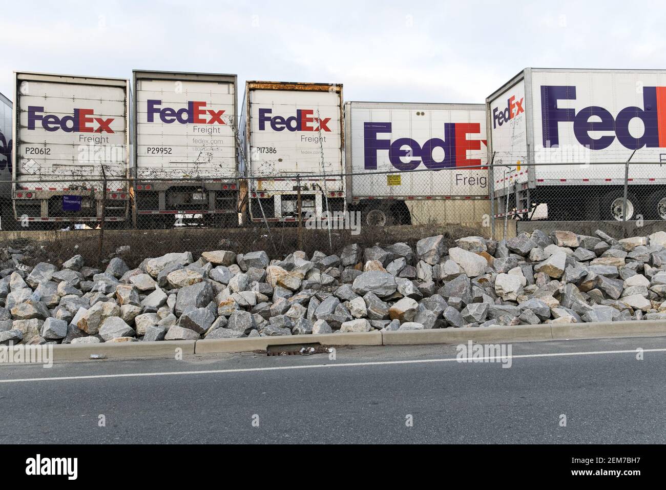 Logo signs on a row of FedEx Freight trailers at a distribution center