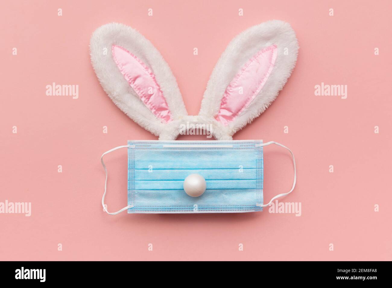 Coronavirus Easter bunny face made from rabbit ears and a protective face mask Stock Photo