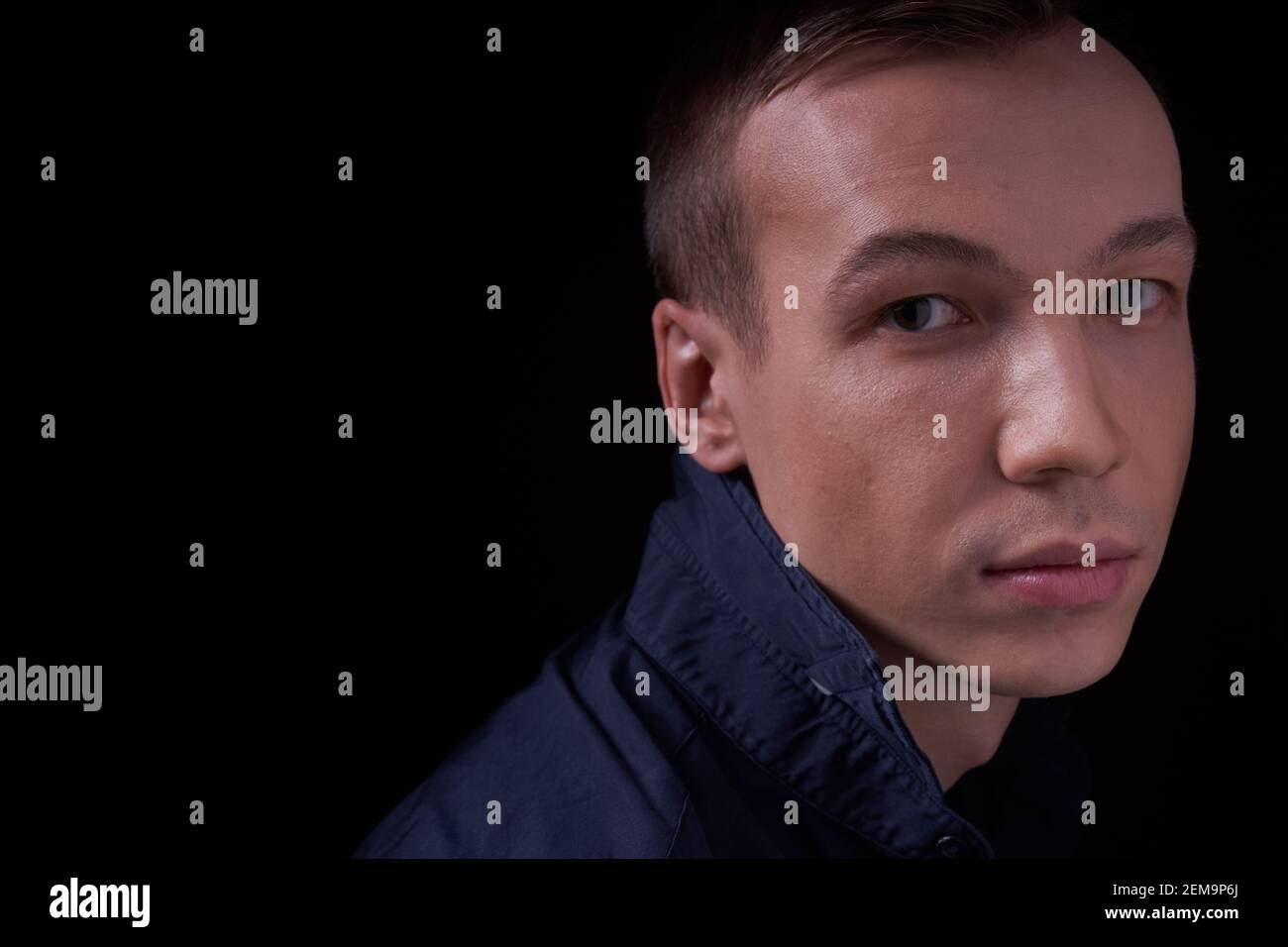 Close up portrait of a beautiful confident young man on a black isolated background in a Studio with copy space, he looks at the camera Stock Photo