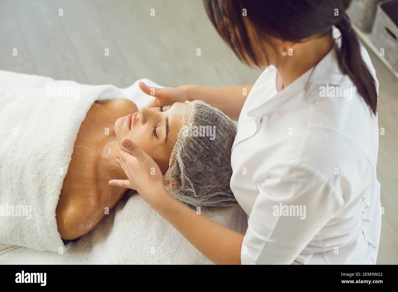 Face massage. Close-up of young woman getting spa massage treatment at beauty spa salon. Stock Photo