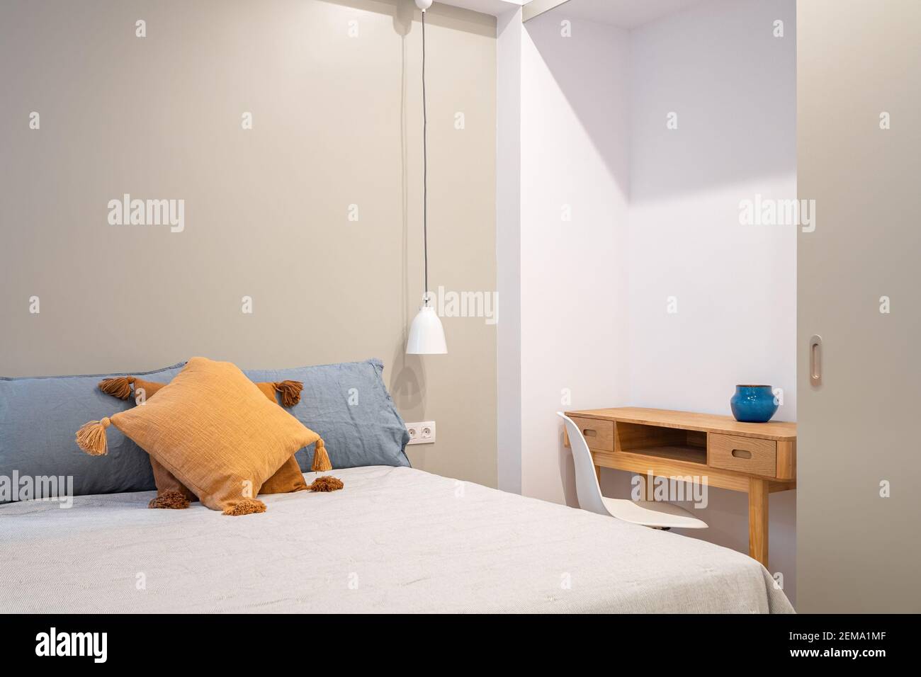 Interior of modern bedroom with small table and chair. Bright room with