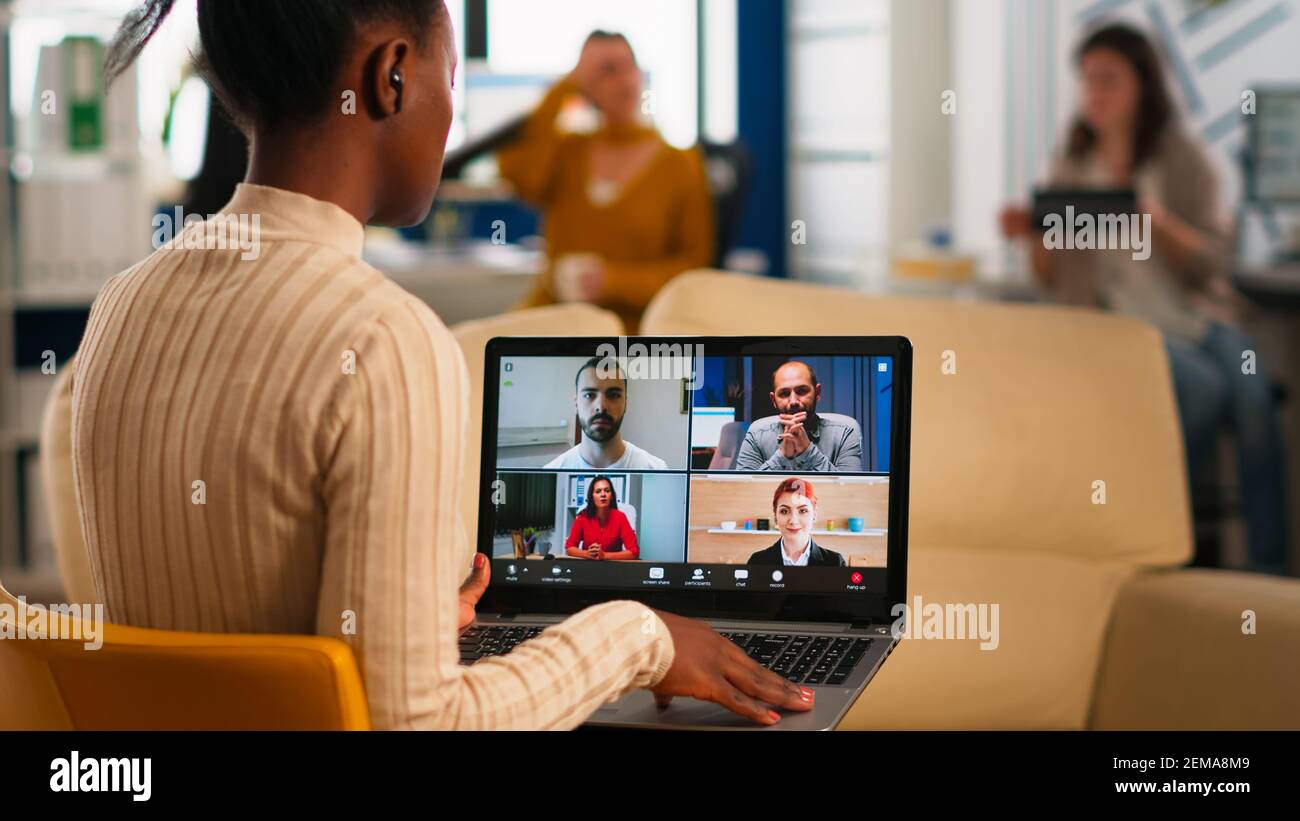 Over the sholder shot of employee talking with partners using video ...
