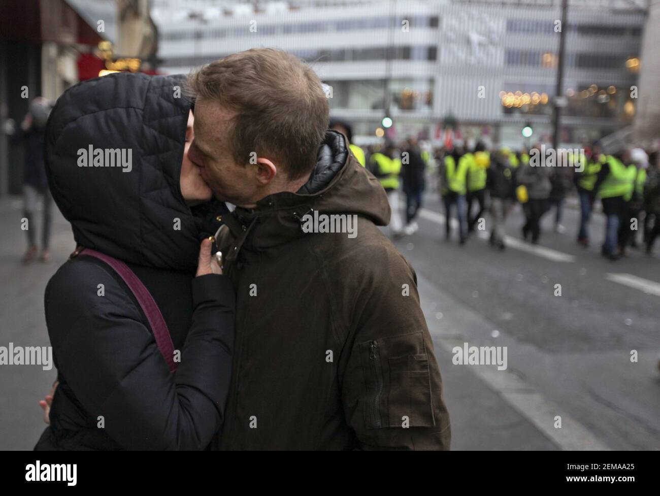 19 January 2019. Paris, France. Gilets Jaunes - Acte X take to the streets  of Paris. Love on the march, a couple kiss as they march with the Gilets  jaunes. An estimated