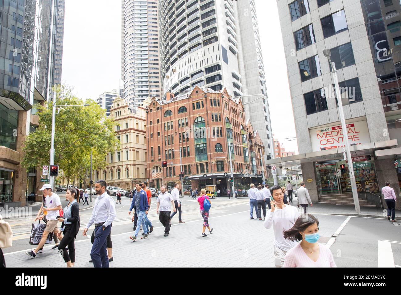 Sydney city centre road interchange pedestrians cross the road, facemasks due to covid 19,Sydney,Australia Stock Photo