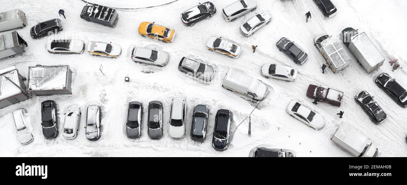 Aerial view of automobile moving lot with cars and pedestrians in winter with snow from above Stock Photo