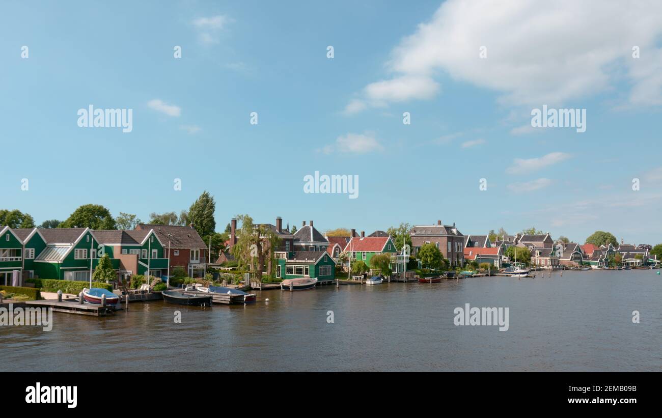 Beautiful traditional dutch houses on the banks of the river zaan, in the suburbs of Amsterdam in the Netherlands. Stock Photo