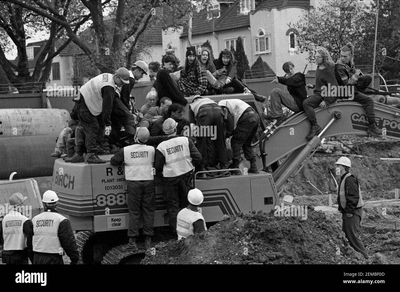 Security guards attempt to remove anti road protesters occupying diggers on the site of the M11 Link Road in East London. The machines were occupied in an attempt to stop road construction. The protests lasted 2 years and ended up almost doubling the cost of the road scheme. - Stock Image