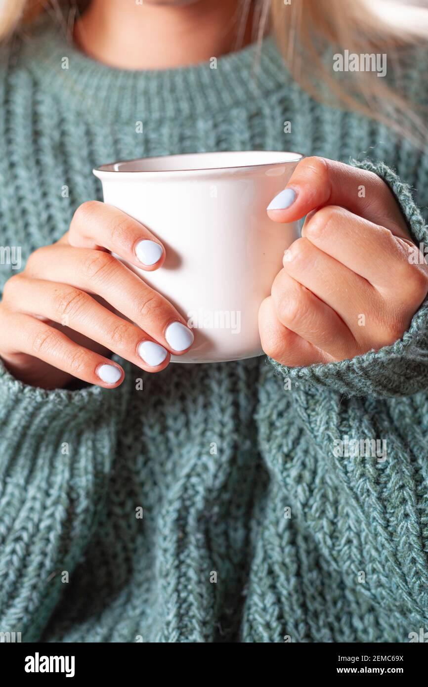 Female hands holding mug of hot tea with lemon in morning. Young ...