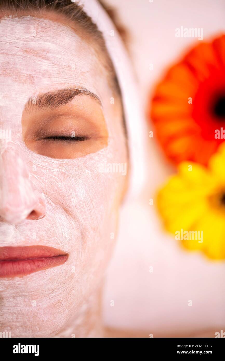 Woman with cosmetic face mask for evening of roughness and ...