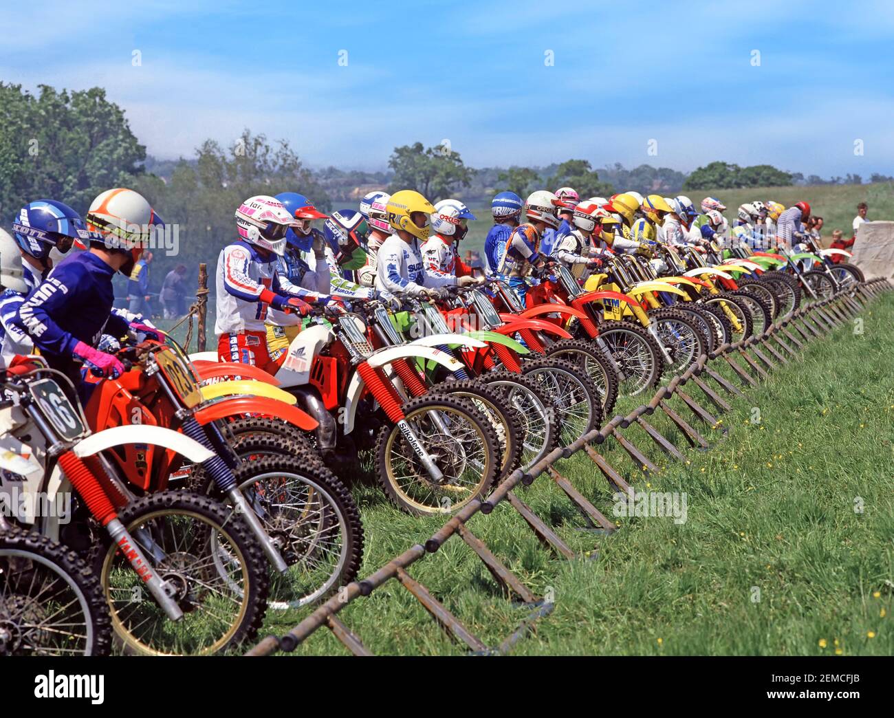 Close Up Motorcycle Riders Colourful Image Of Youngsters Lining Up At A Start Gate For Motorbike Grass Track Scramble Cum Motocross Dirt Bike Scrambler Race Circuit Across Hilly Farmland Sport Archive 1980s